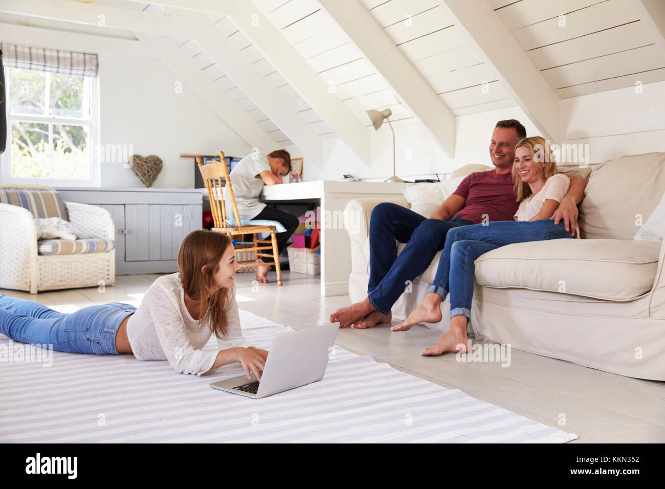 Familie mit Kindern im Teenageralter mit Technologie zu Hause Stockfoto