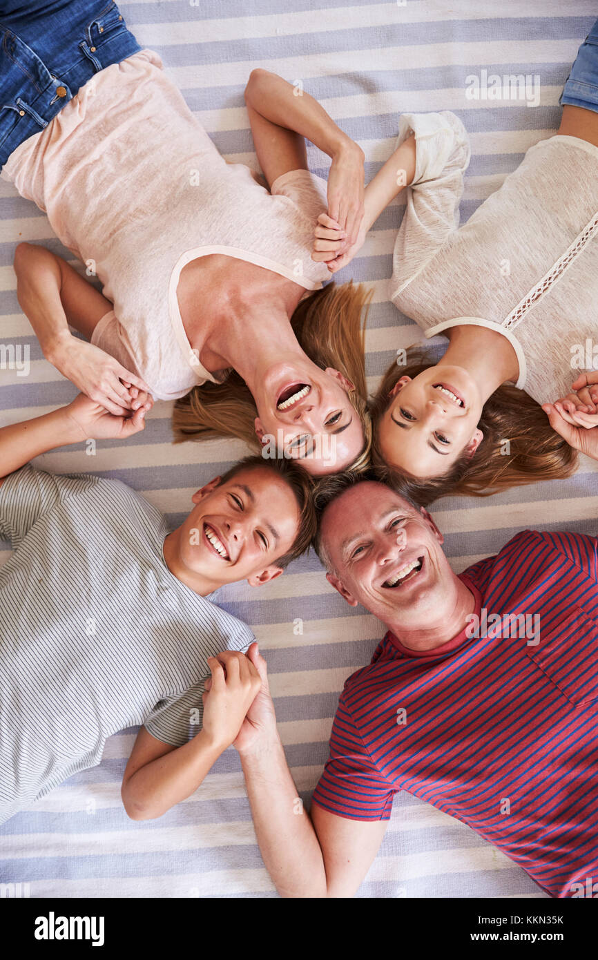 Ansicht von oben von Familien mit Kindern im Teenageralter liegend auf Bett Stockfoto