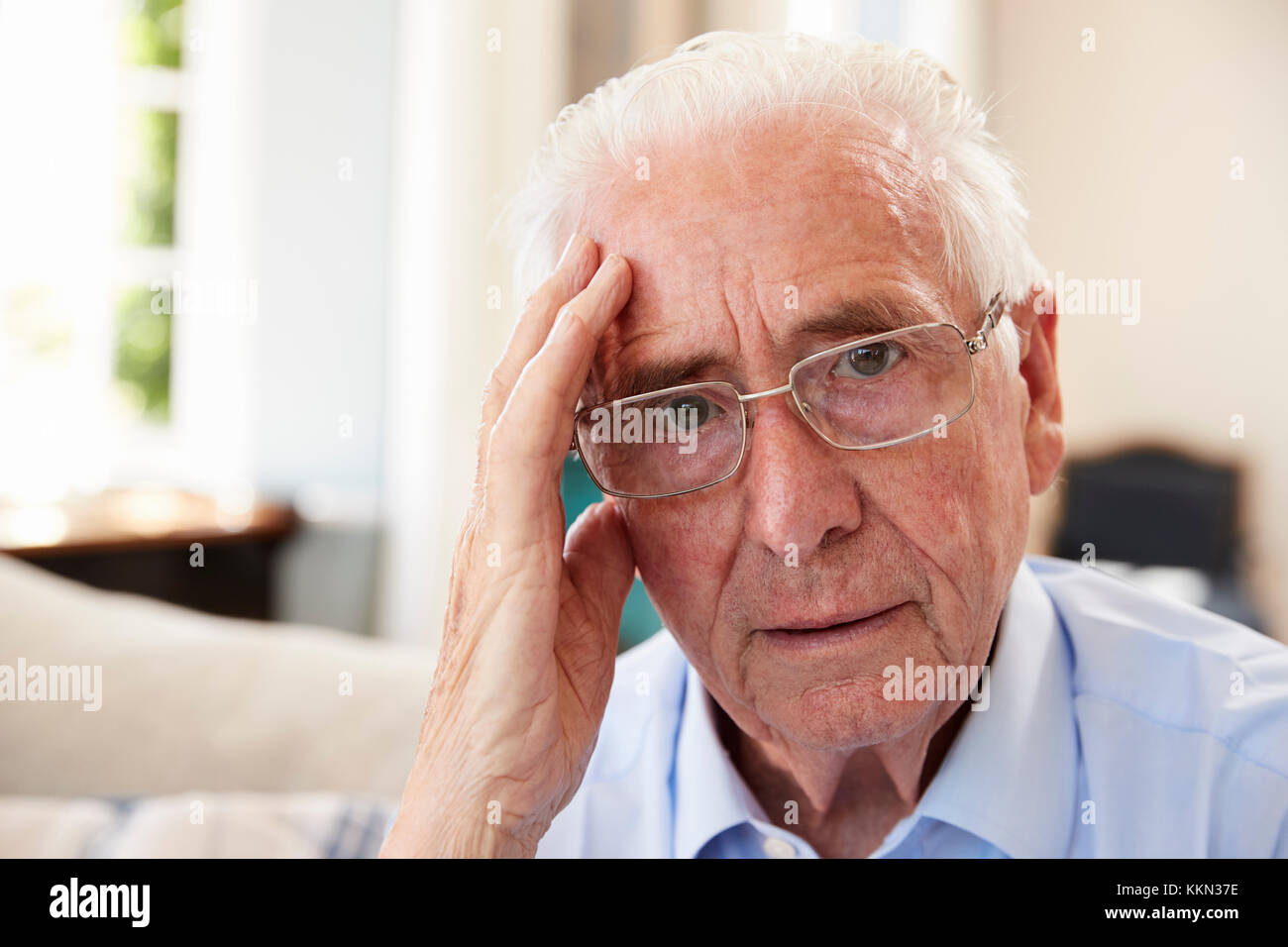 Portrait von älteren Mann sitzt auf einem Sofa, die unter Depressionen leiden Stockfoto