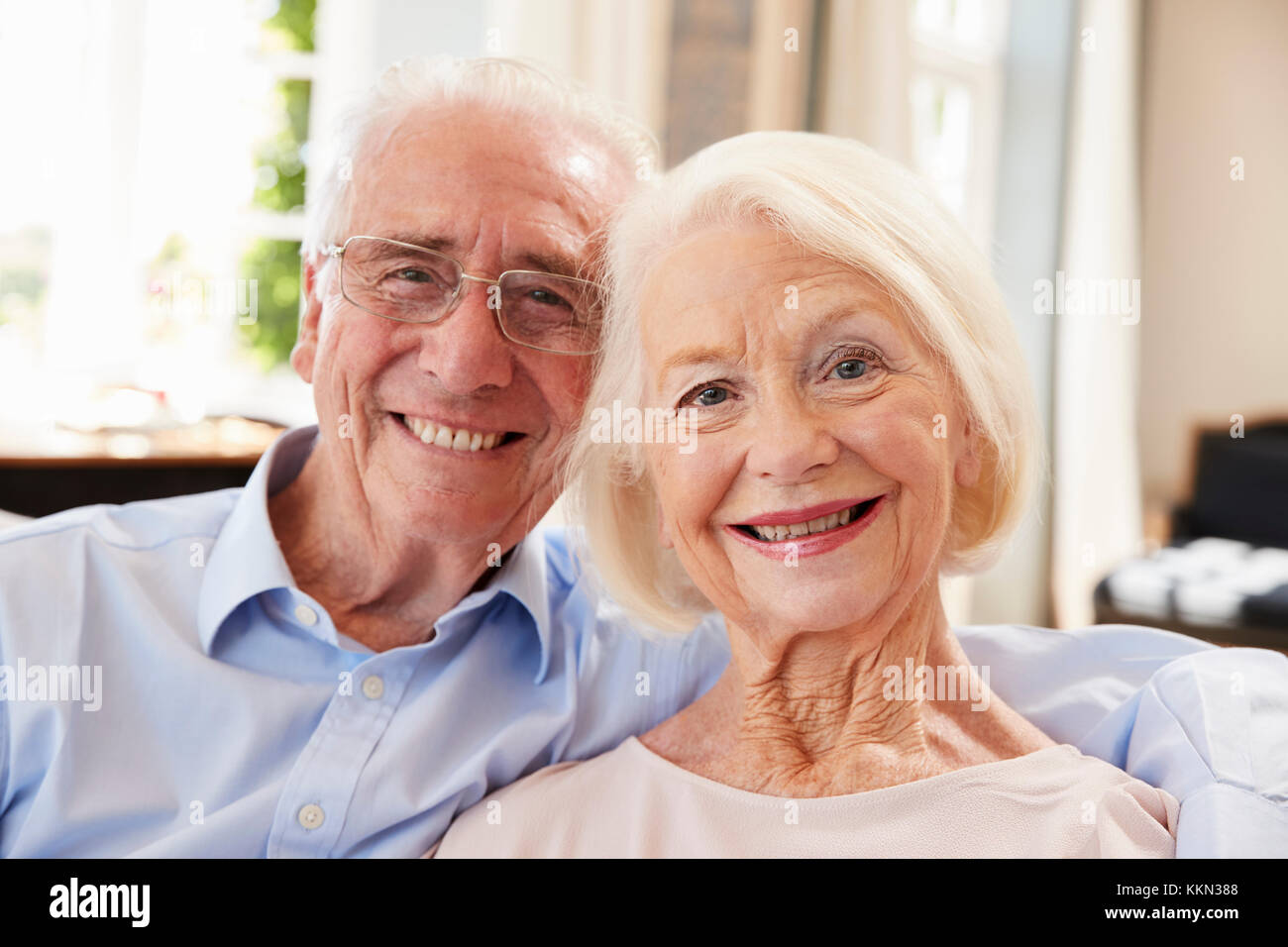 Portrait Of Smiling älteres paar zu Hause auf dem Sofa sitzen Stockfoto