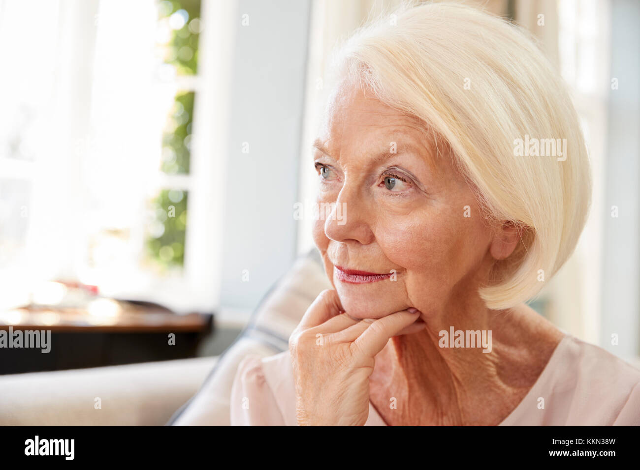 Ältere Frau sitzt auf einem Sofa zu Hause, die unter Depressionen leiden Stockfoto