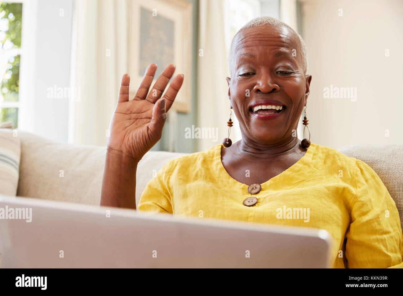 Ältere Frau mit Laptop zu verbinden Mit der Familie für Videokonferenz Stockfoto