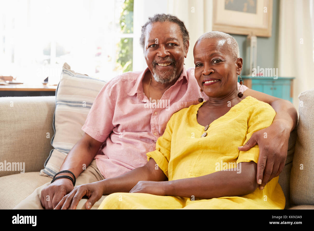 Portrait Of Smiling älteres paar zu Hause auf dem Sofa sitzen Stockfoto