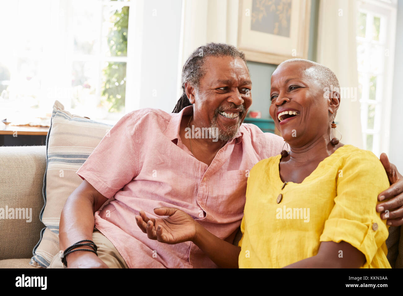 Lächelnd Senior Paar auf dem Sofa zu Hause sitzen zusammen Stockfoto