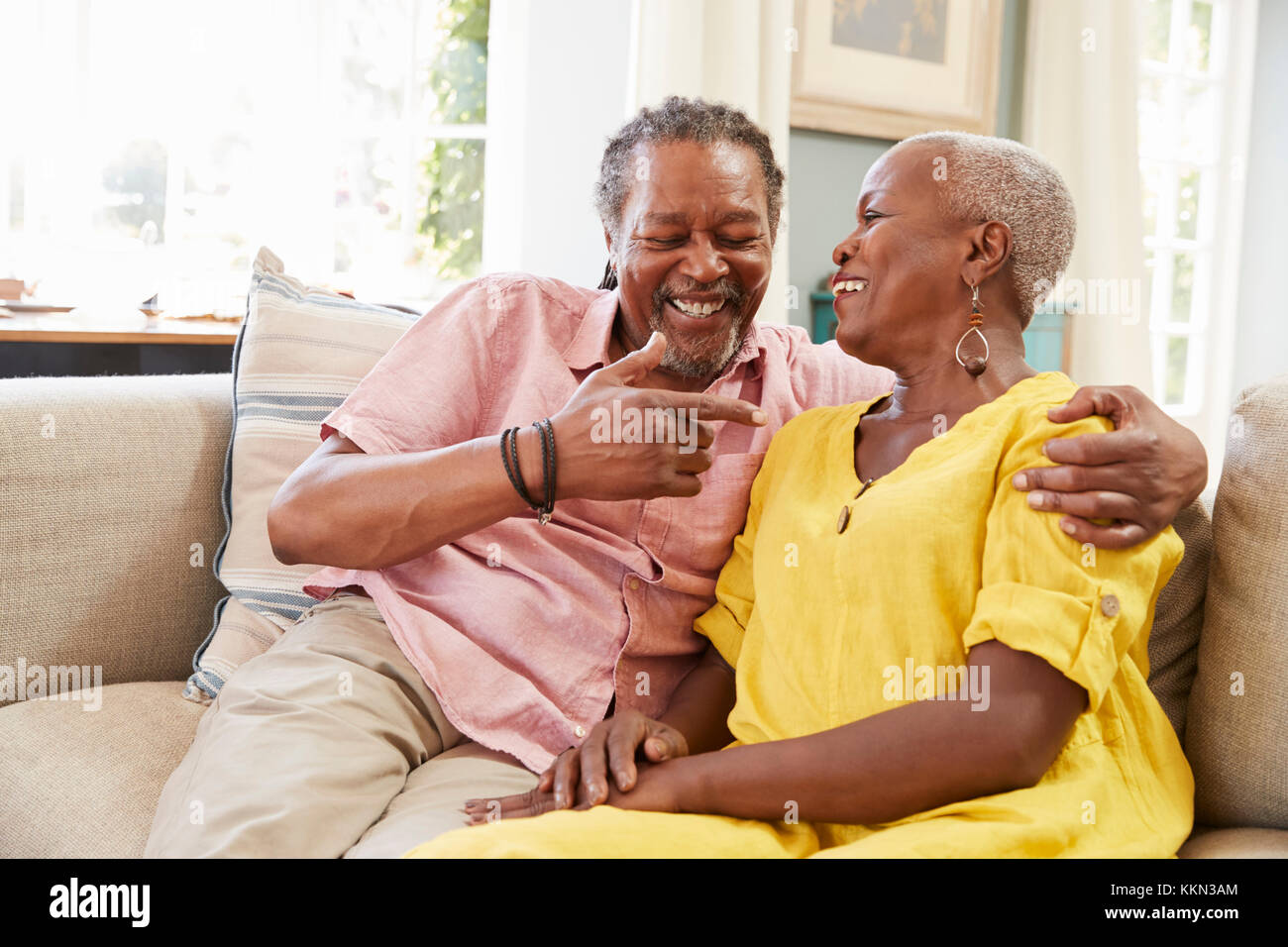Lächelnd Senior Paar auf dem Sofa zu Hause sitzen zusammen Stockfoto