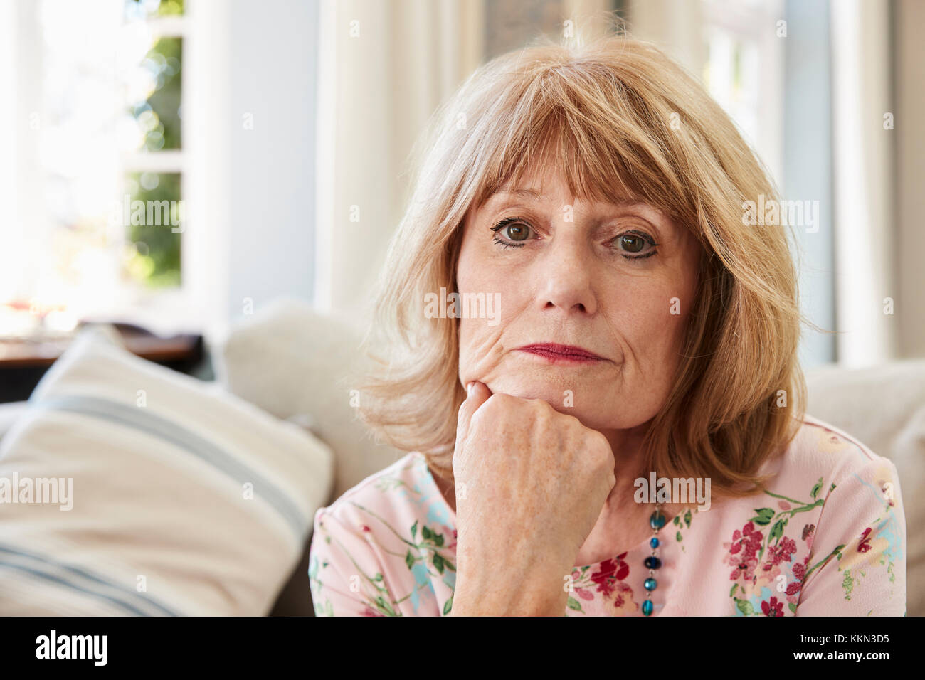 Portrait der älteren Frau auf Sofa, die unter Depressionen leiden Stockfoto