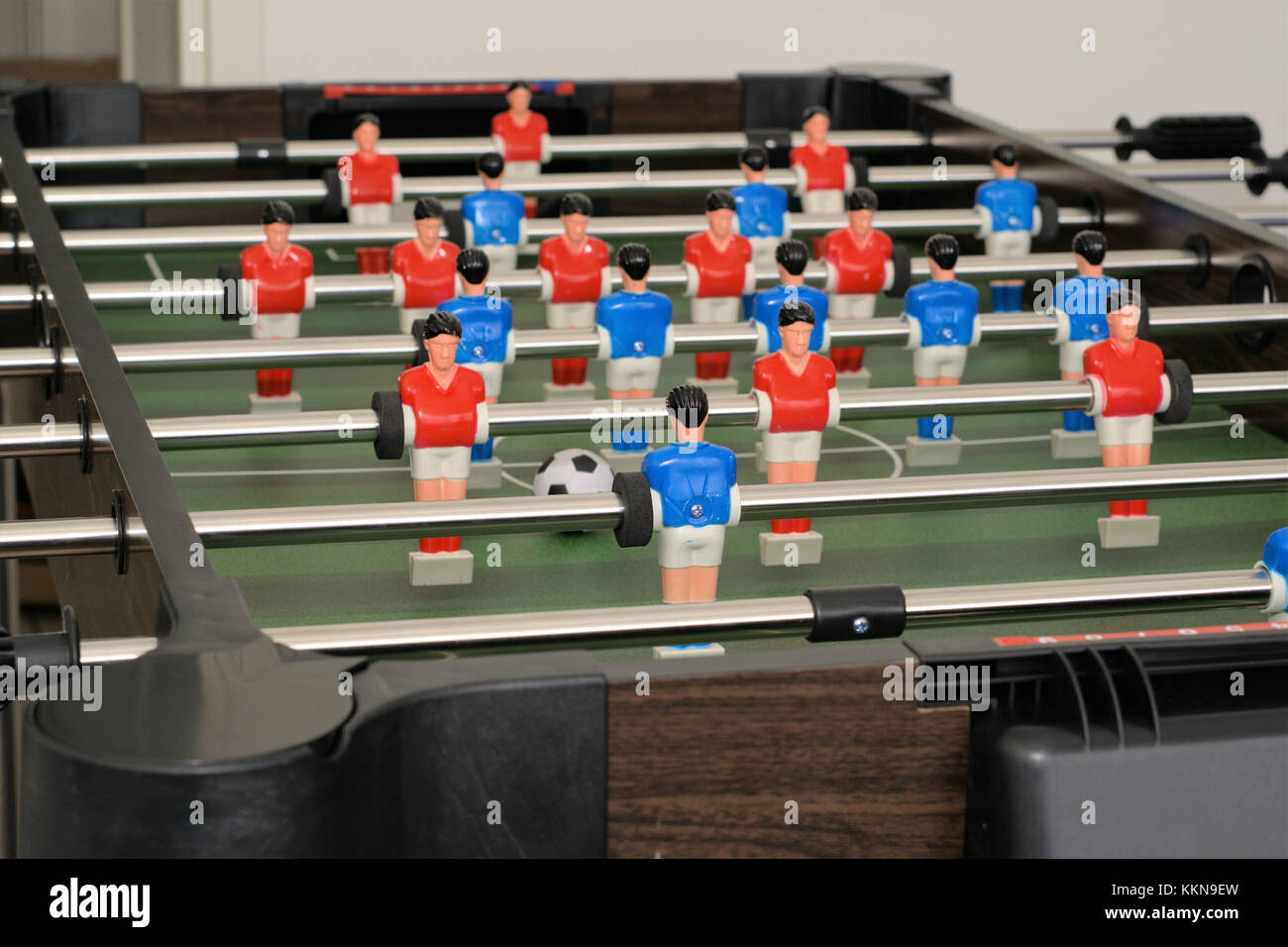 Tischfußball oder Kicker. Kunststoff Figuren oder foosball Männer aus Kunststoff mit schwarzen und weißen Ball. Stockfoto