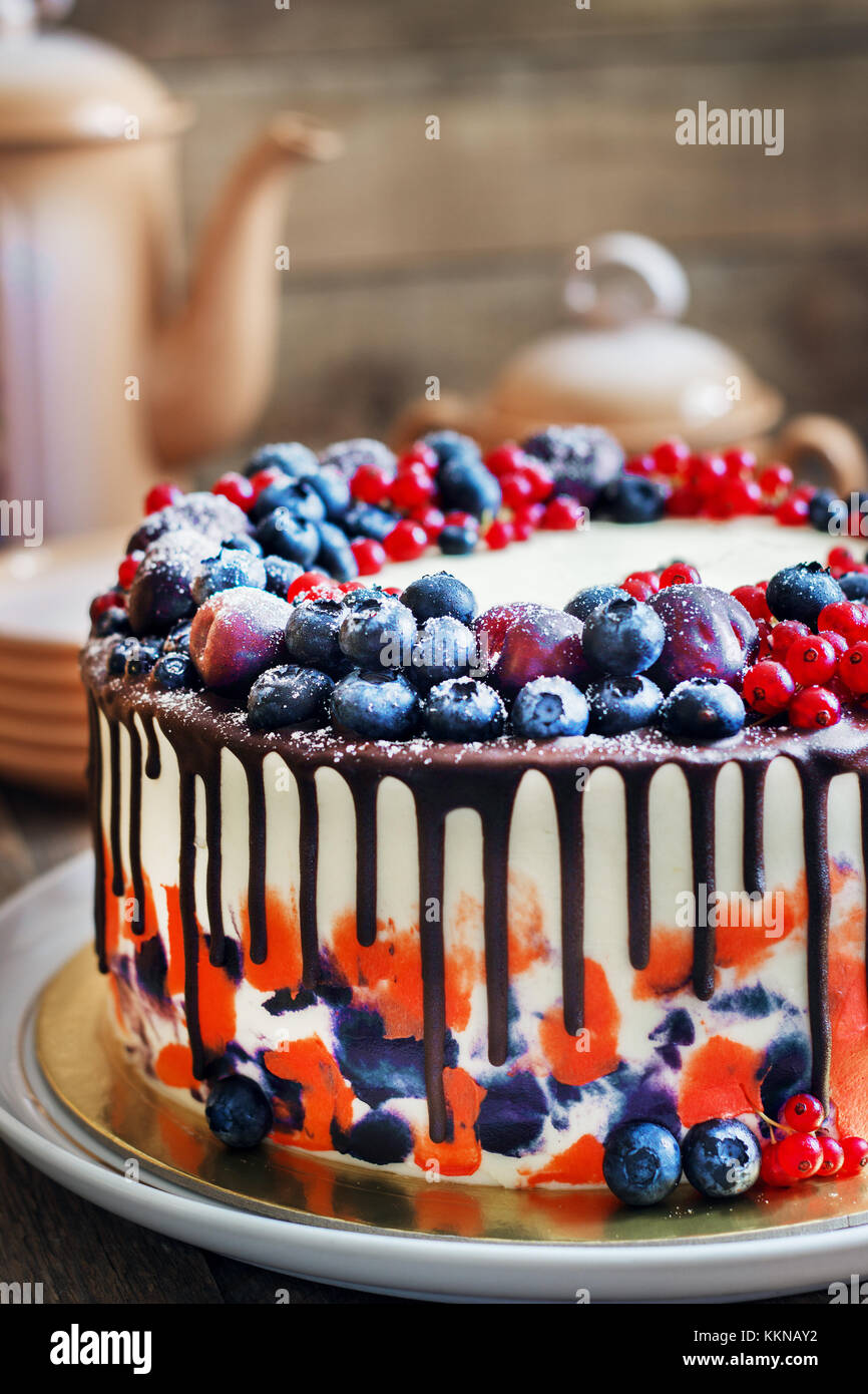 Helle festliche Kuchen mit Beeren und Schokolade auf einem dunklen Hintergrund, rustikalen Stil Stockfoto
