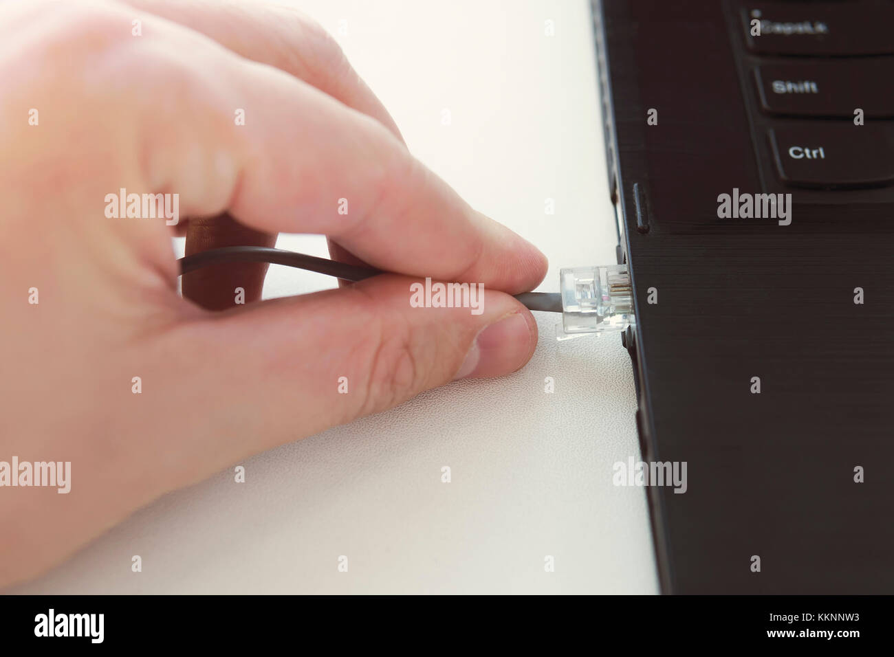 Ethernet Kabel Stecker auf dem Computer Laptop Tastatur Technologie  Konzept. Hand halten Netzwerkkabel closeup. Anschluss Patchkabel RJ45  Laptop Stockfotografie - Alamy