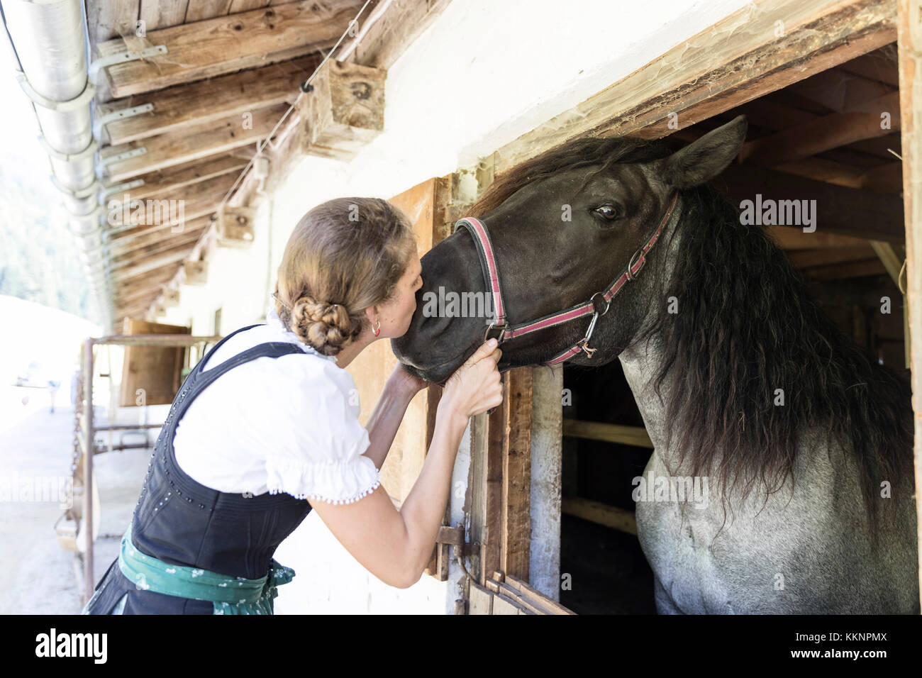 Farmwoman mit Dirndl Küsse ein Pferd Stockfoto