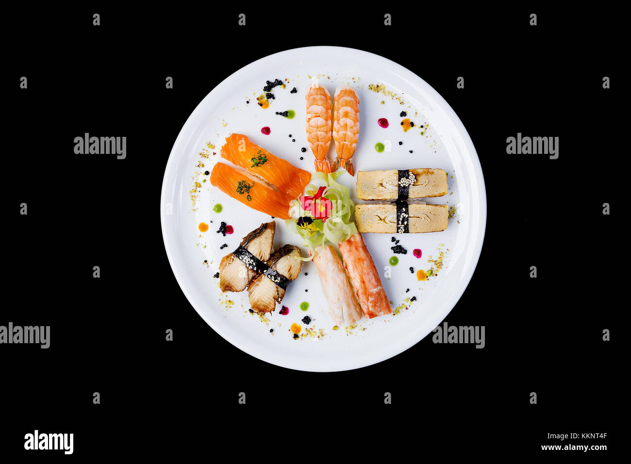 Sashimi auf eine weiße, runde Platte mit kleinen Blüten, die japanische Küche eingerichtet. der Ansicht von oben auf einem schwarzen Hintergrund isoliert Stockfoto