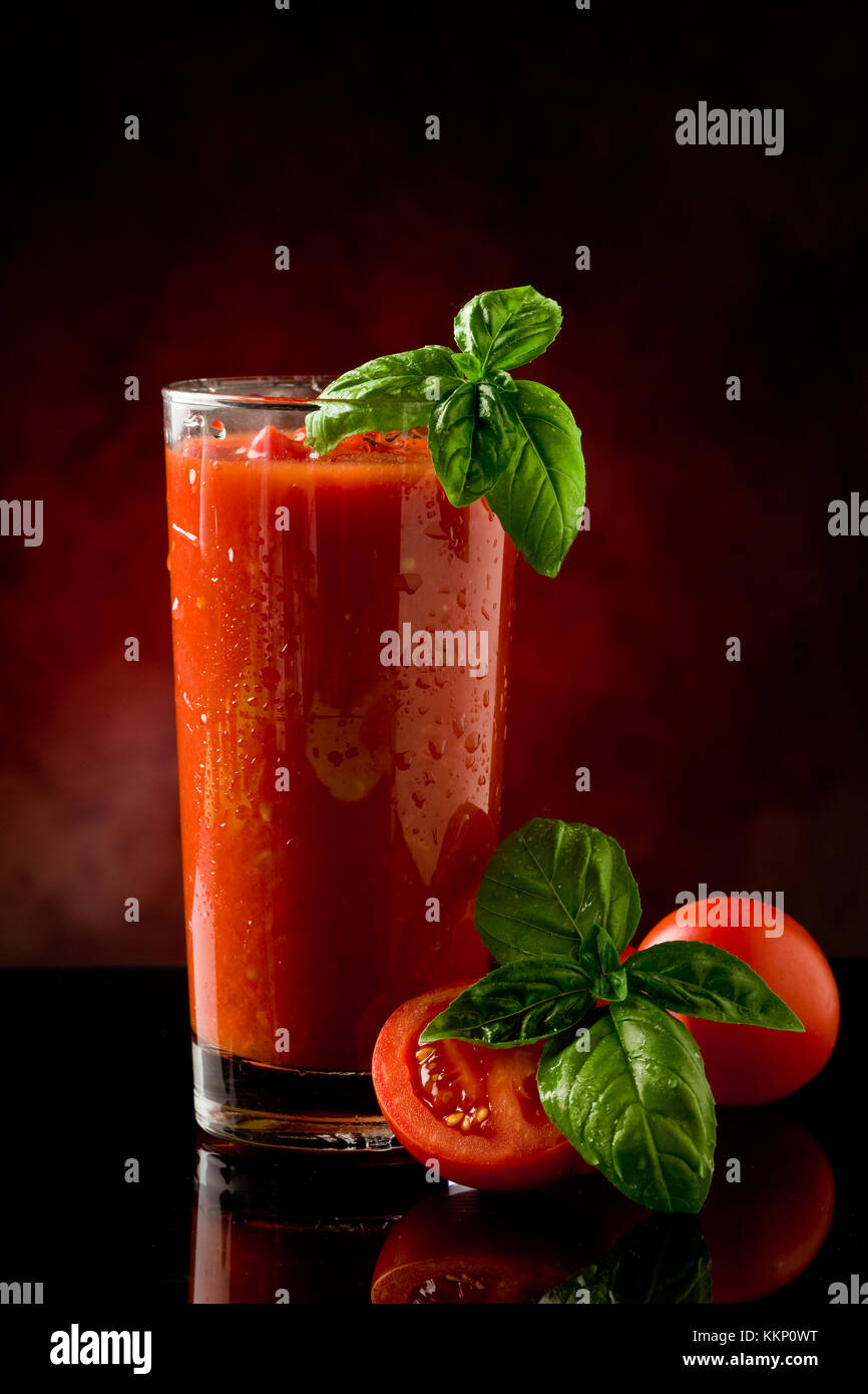 Foto von leckeren Tomaten Bloody Mary cocktail auf Glastisch mit spot-Licht reflektierenden Stockfoto
