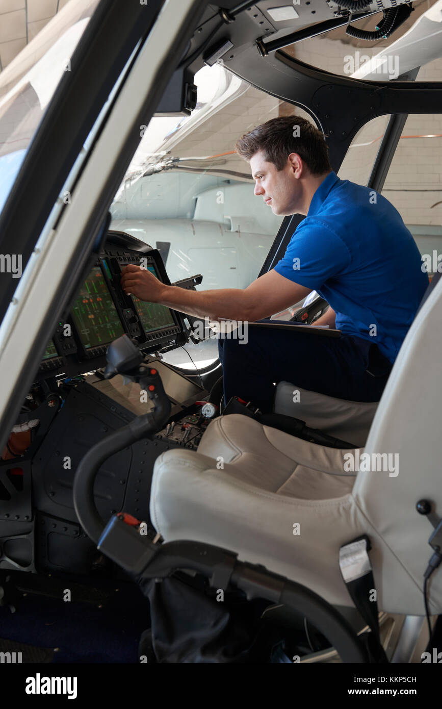 Männliche aero Ingenieur mit Zwischenablage in Helicopter Cockpit arbeiten Stockfoto
