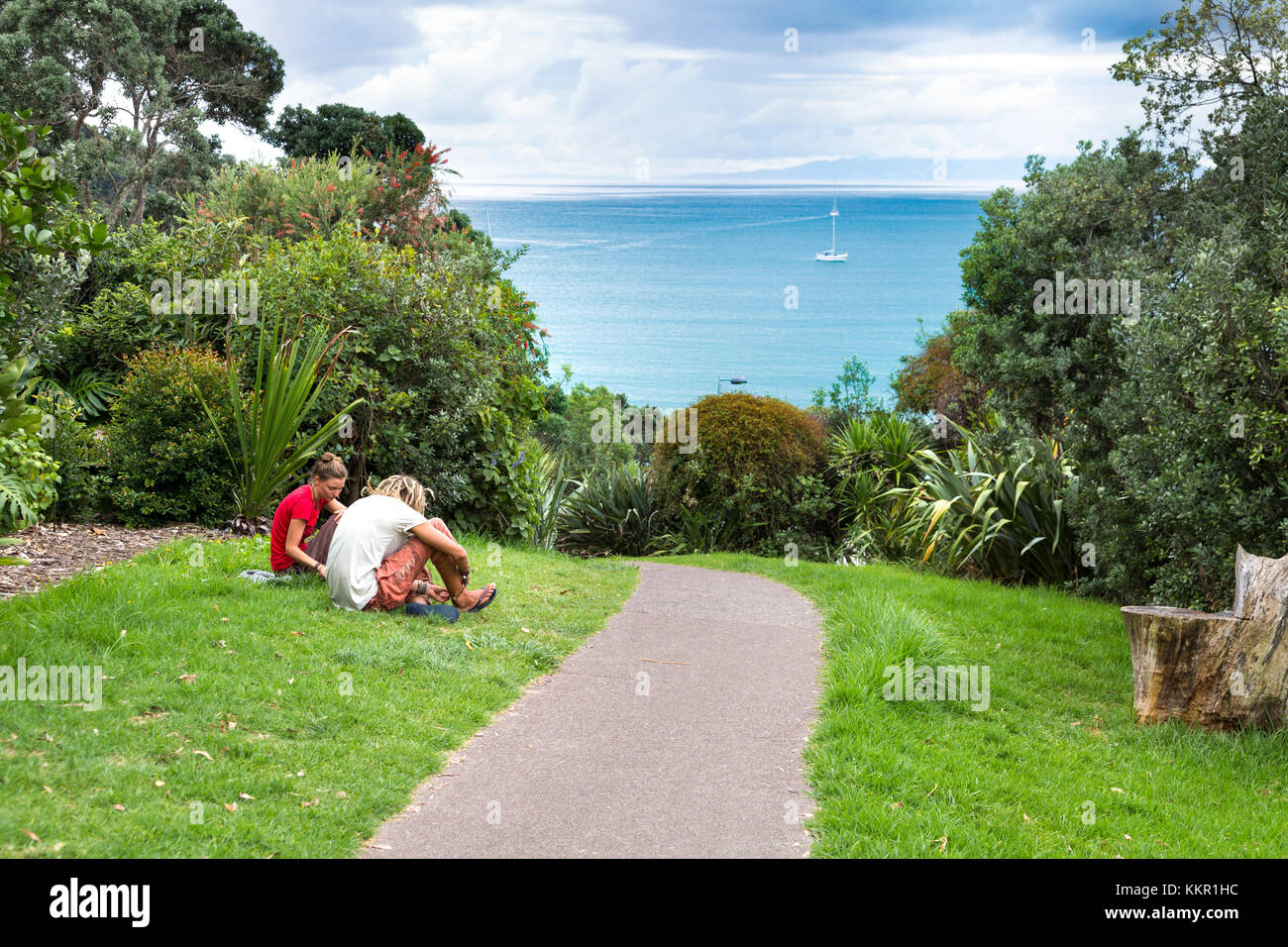Zwei Personen sitzen auf das Gras in Waiheke Island, Neuseeland Stockfoto