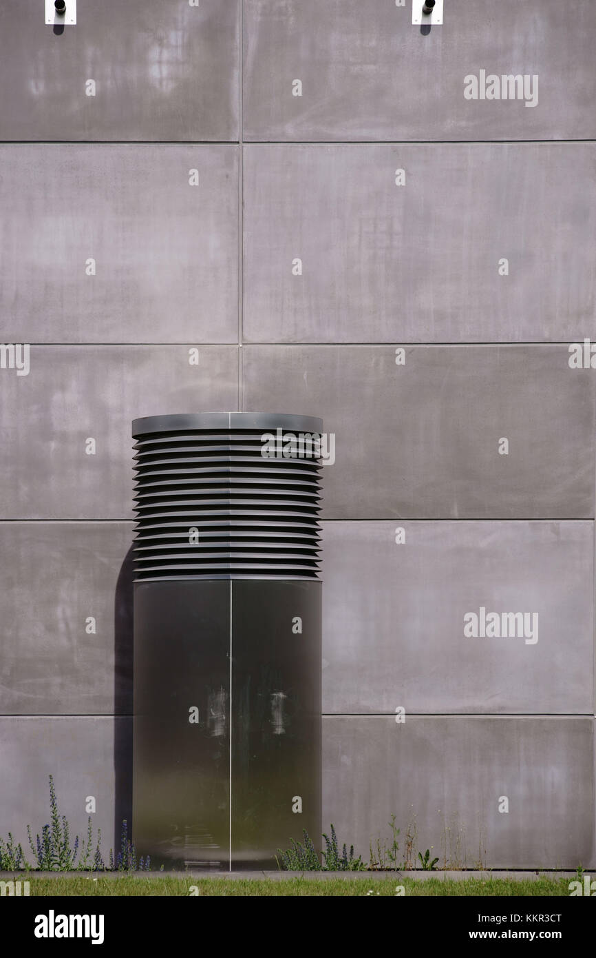 Eine Ventilationshaube aus Edelstahl vor einer markanten Betonfassade. Stockfoto