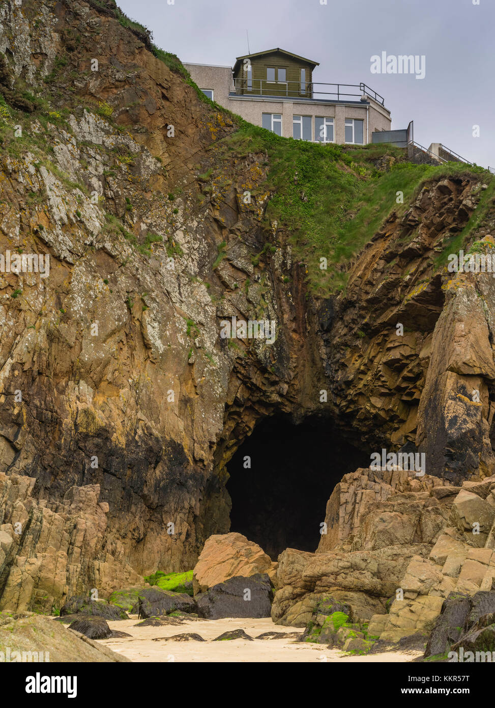 Höhle unter Haus auf Felsen Stockfoto