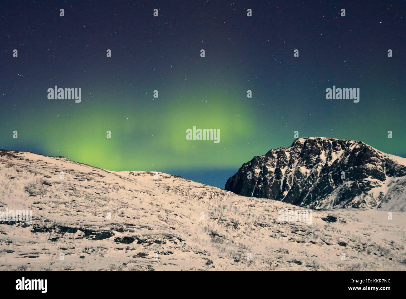 Nordlicht und Sterne auf den schneebedeckten Gipfeln in die arktische Polarnacht Bergsbotn Senja Tromsø Norwegen Europa Stockfoto