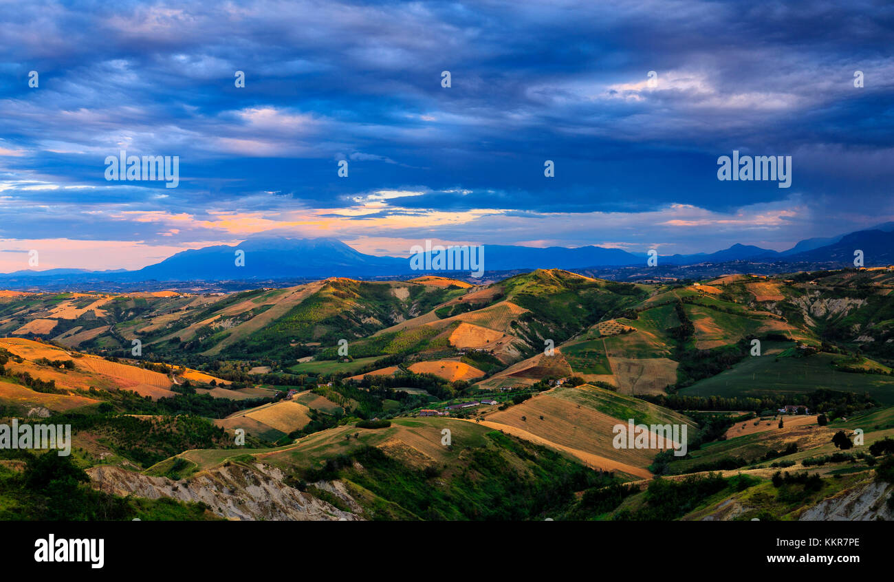 Hügeln mit Blick auf Majella Gruppe durch die Sonne bei Sonnenuntergang beleuchtet. Calanchi von Alba Adriatica, Abruzzen, Italien. Stockfoto