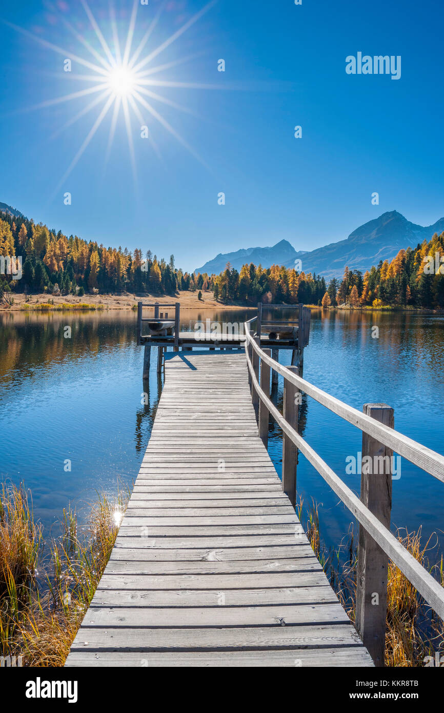 Holzsteg am Bergsee mit Sonne im Herbst, See Starz, st. moritz, Engadin, Graubünden, Schweiz Stockfoto