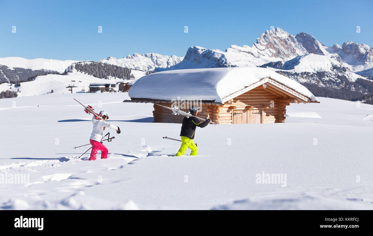 Zwei Skifahrer sind zu Fuß in den frischen Schnee auf der Seiser Alm, Provinz Bozen, Südtirol, Trentino Alto Adige, Italien Stockfoto