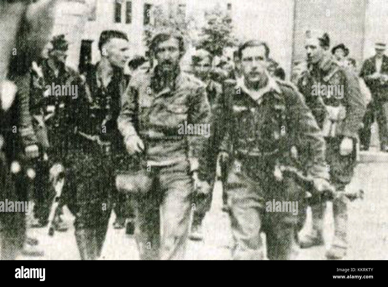 Das Bild zeigt Partisanen, die nach ihrem Sieg in der Schlacht von Ljubno einen deutschen Soldaten anführen, was die komplexe Geschichte des Zweiten Weltkriegs auf dem Balkan widerspiegelt. Stockfoto