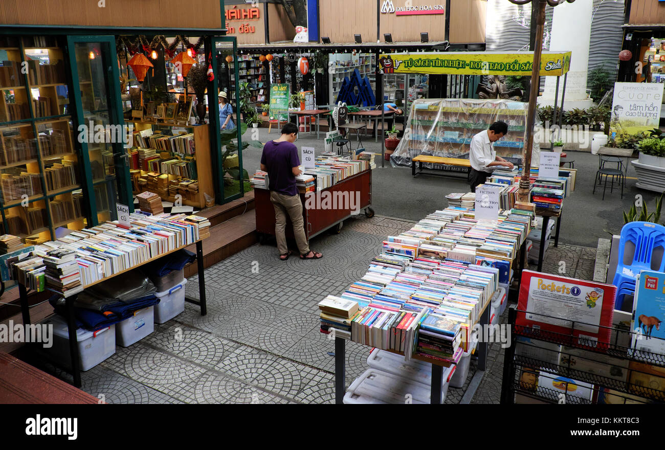 Ho Chi Minh, Viet Nam, Reader lesen Buch im Buchladen, Verlag zeigen bunte Bücher outdoor Shop, Lesen in der modernen Gesellschaft verloren geht. Stockfoto