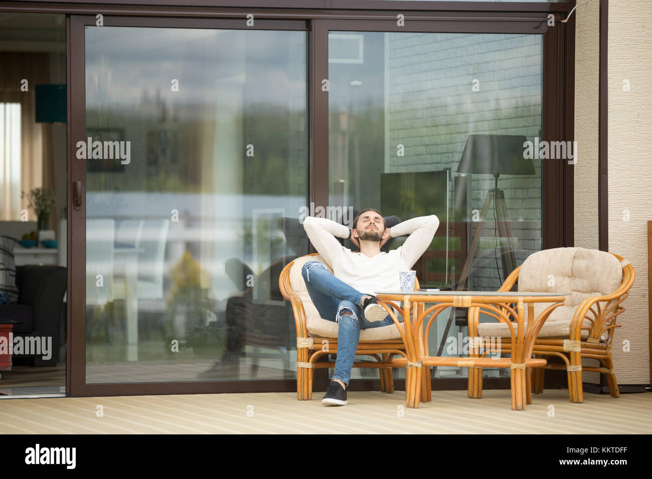 Junger Mann sitzen auf der Terrasse entspannen, die frische Luft Stockfoto