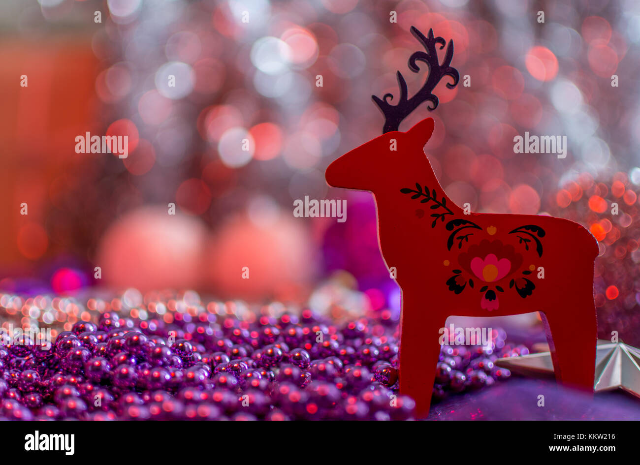 Weihnachtsschmuck eines roten regen Rehe in geringer Tiefenschärfe. cremig roten Hintergrund. Stockfoto