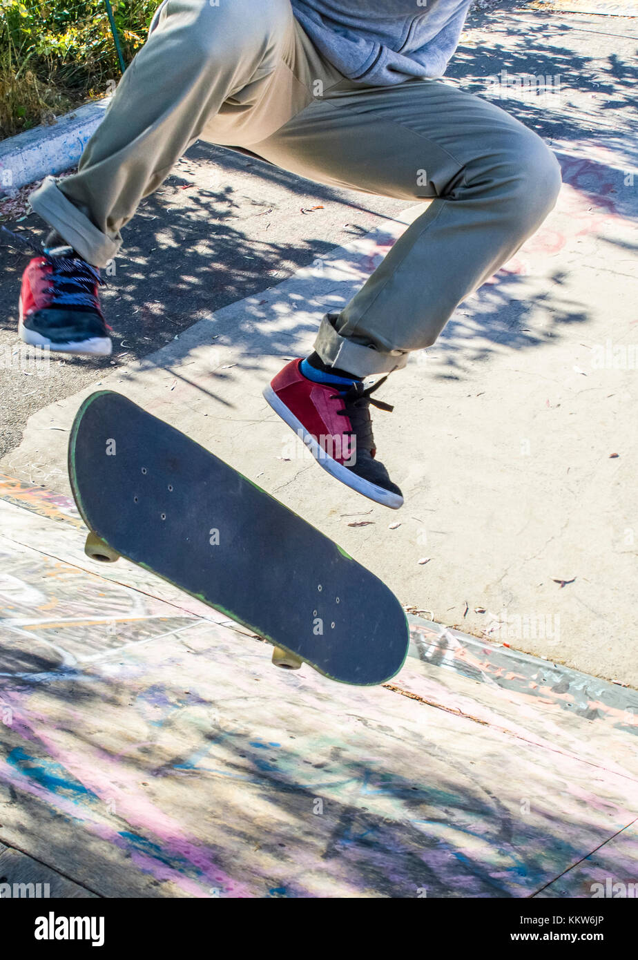 Ein Kerl mit einem kickflip Skateboard. Stockfoto