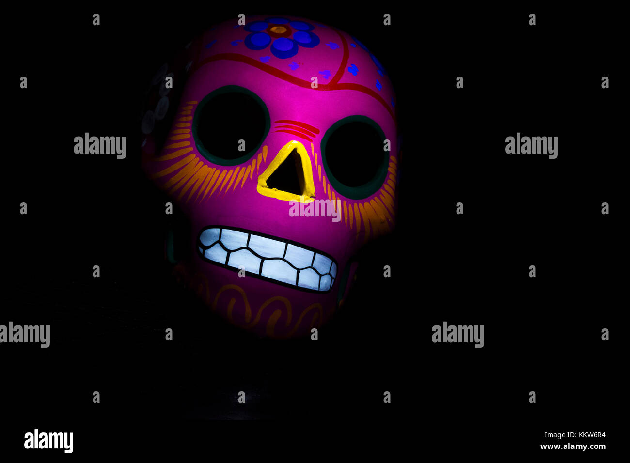 Ein rosa mexikanischen Schädel auf einem dunklen Hintergrund. Stockfoto