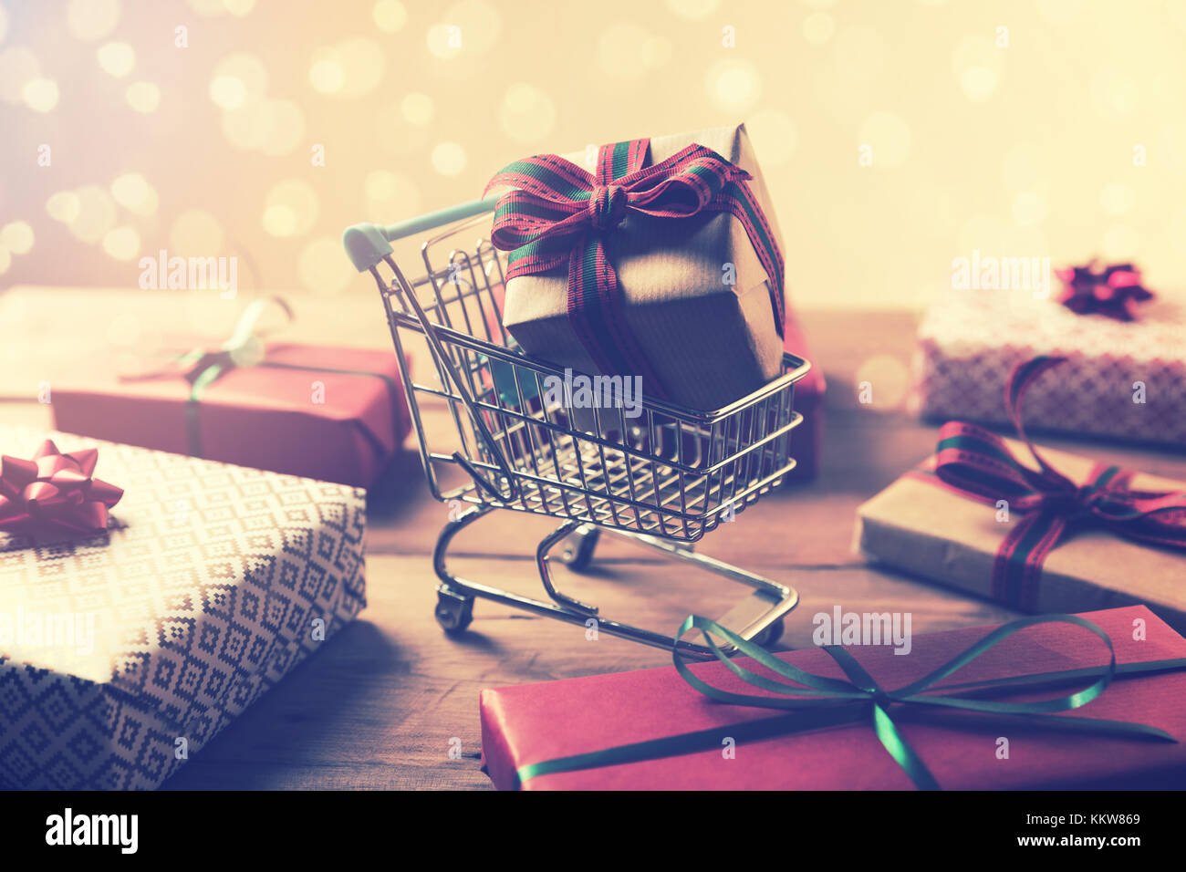 Geschenke kaufen - verpackt in Warenkorb auf bokeh Hintergrund Stockfoto