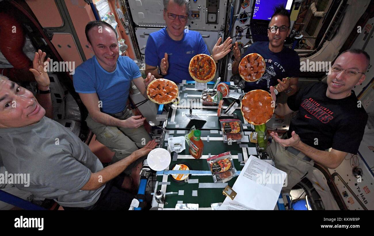 Expedition 53 Crew Mitglieder zeigen Sie Pizzen, die Sie für das Abendessen an Bord der Internationalen Raumstation Dezember 2, 2017 in die Erdumlaufbahn. Crew sind von links nach rechts: Mark vande Hei, Sergey Ryazanskiy, Paolo Nespoli, Joe acaba und Randy Bresnik. Stockfoto