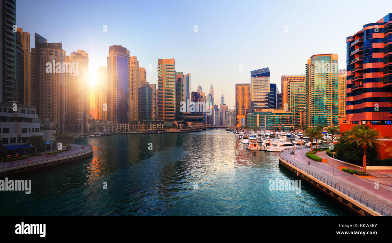 Dubai Skyline am Abend. Luxus in Dubai Sonnenuntergang. Sonne scheint durch Wolkenkratzer an der Marina in Dubai. Stockfoto