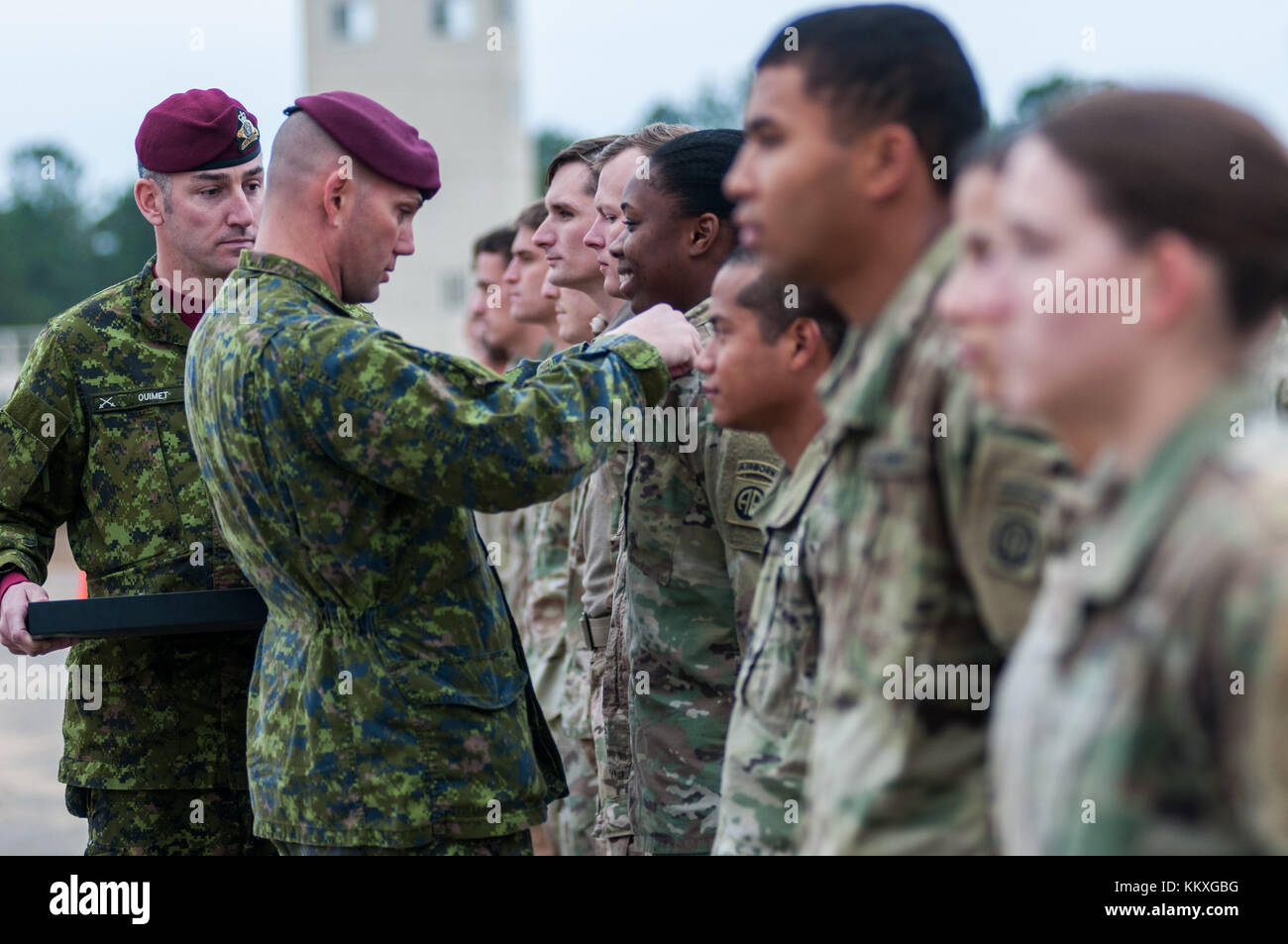 Fort Bragg, NC, USA. Dezember 2017. 2. Dezember 2017 - FORT BRAGG, N.C., USA - Major Mat Gauthier der kanadischen Armee präsentiert Fallschirmjägern der US-Armee Kanadische Sprungflügel, nachdem sie einen Sprung in der Sicily Drop Zone für die 20. Jährliche Randy Oller Memorial Operation Toy Drop absolviert haben, die vom United States Army Civil Affairs & Psychological Operations Command (Airborne) veranstaltet wird. Die jährliche Veranstaltung, die als die weltweit größte kombinierte Luftlandeoperation mit Fallschirmjägern aus neun alliierten Nationen gilt, bietet Fallschirmjägern die Möglichkeit, Kindern in Gemeinden zu helfen Stockfoto