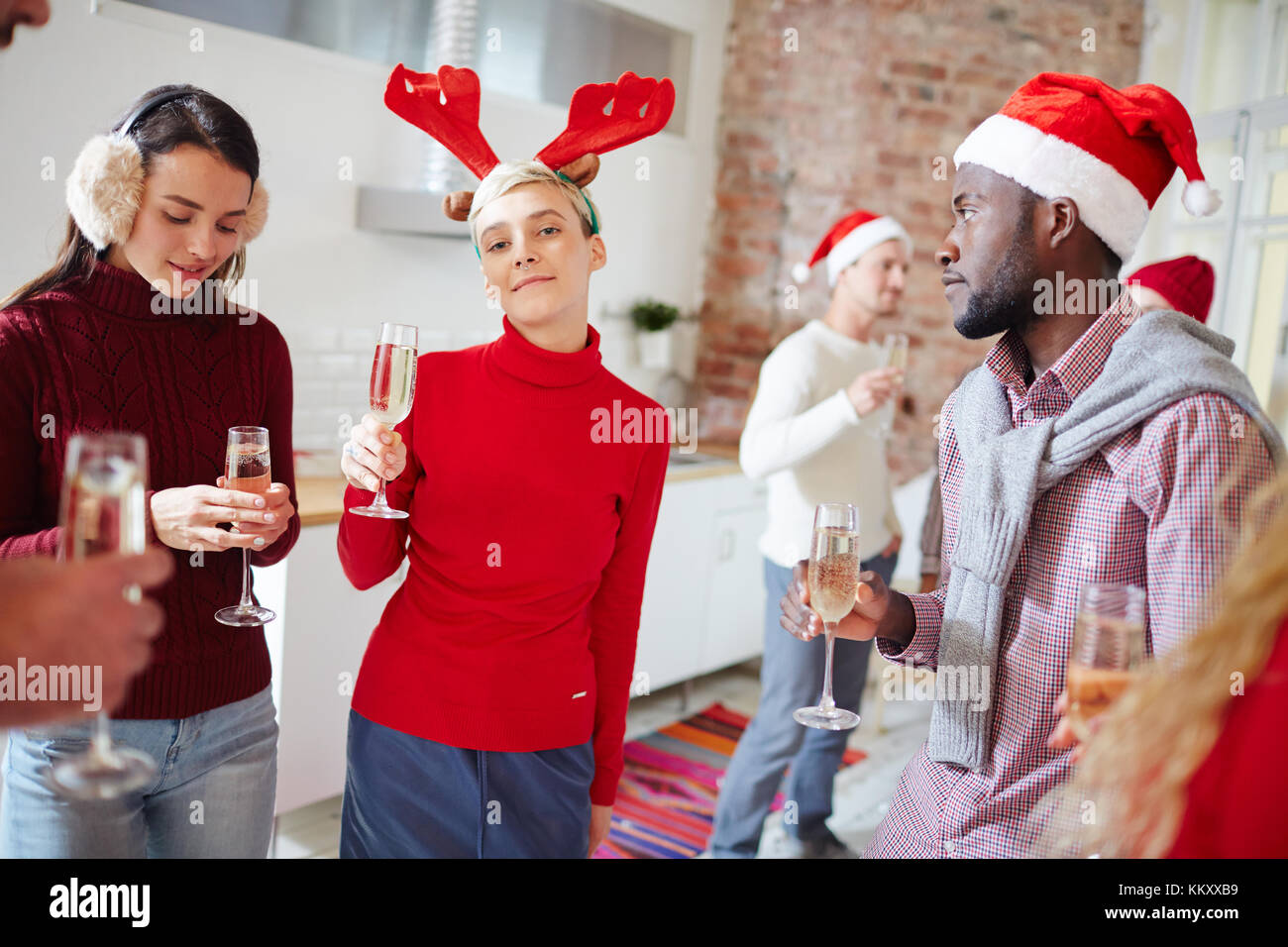 Erholsame Freunde in Weihnachten Kleidung in Home Party mit Champagner bei festlichen Abend Stockfoto