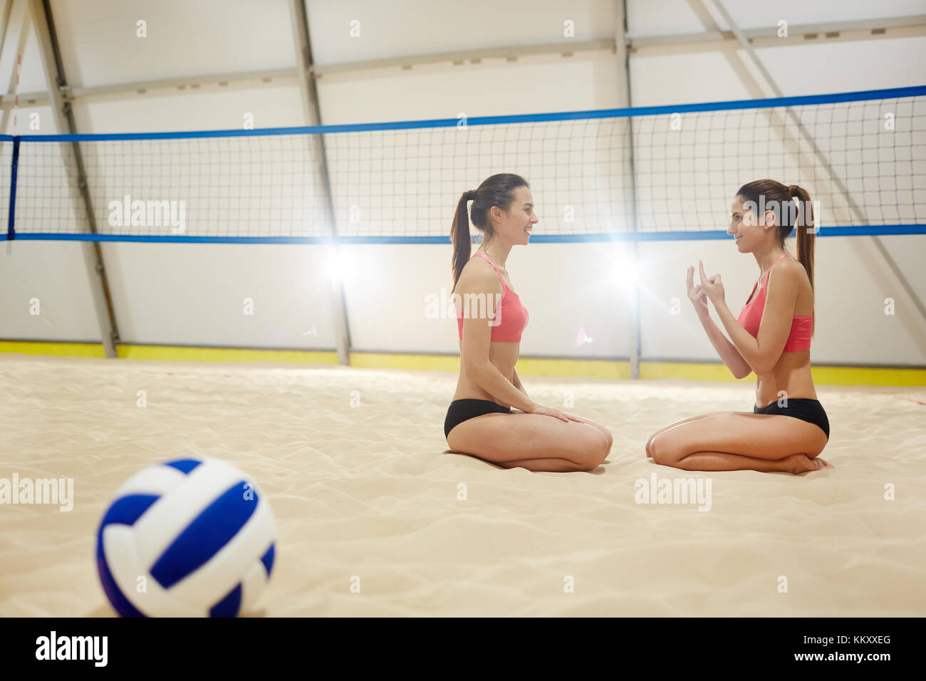 Zwei freundliche sportliche Mädchen reden über den Spielstand während Standortwahl auf Sand Feld Stockfoto