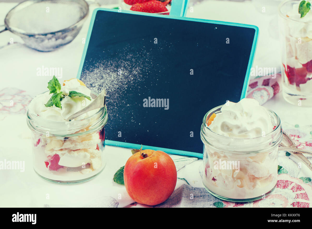 Dessert eton Mess mit Merengue, Beeren und Sahne, die in Gläsern am Tisch serviert mit leeren Tafel in instagram Wirkung Stockfoto