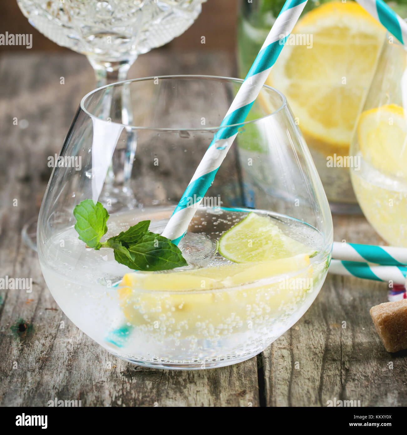 Frische hausgemachte Limonade mit Zitrone, Limette und Minze in Gläser mit Vintage cocktail Schlauch über Holztisch. selektive Fokus, quadratischen Bild Stockfoto