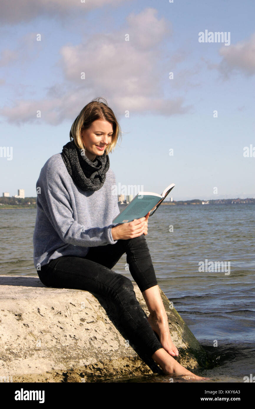 Frau, blond, Ostsee, Freizeit, Sitzen am Strand, ein Buch lesen, Stockfoto