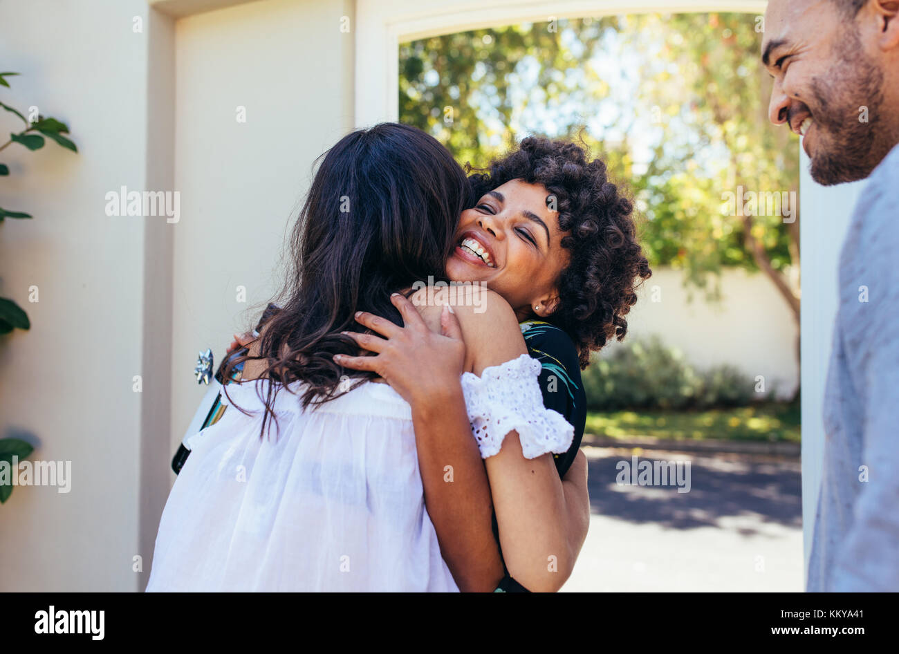 Afrikanische Frau gruss Freundin für in ein neues Haus. Lächelnden jungen Frau gratulieren ihr Freund. Paar einladende Freund für Housewarming p Stockfoto