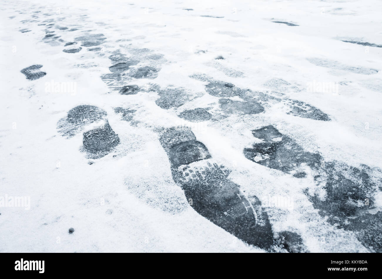 Fußabdrücke in nassen Neuschnee auf einer städtischen Straße Stockfoto