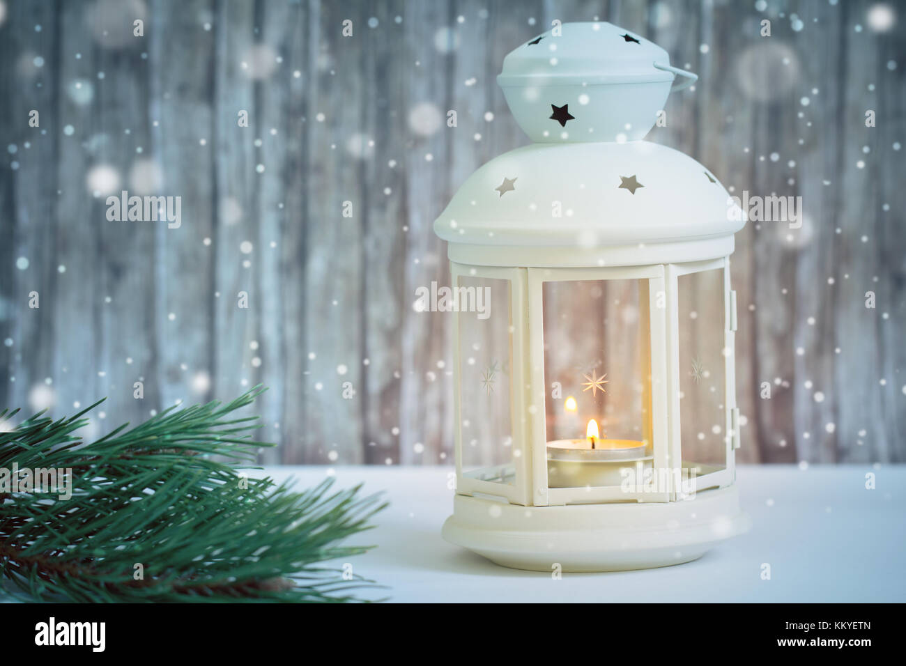 Warme Kerze, Licht in der Laterne mit Schnee und Holz Hintergrund Stockfoto