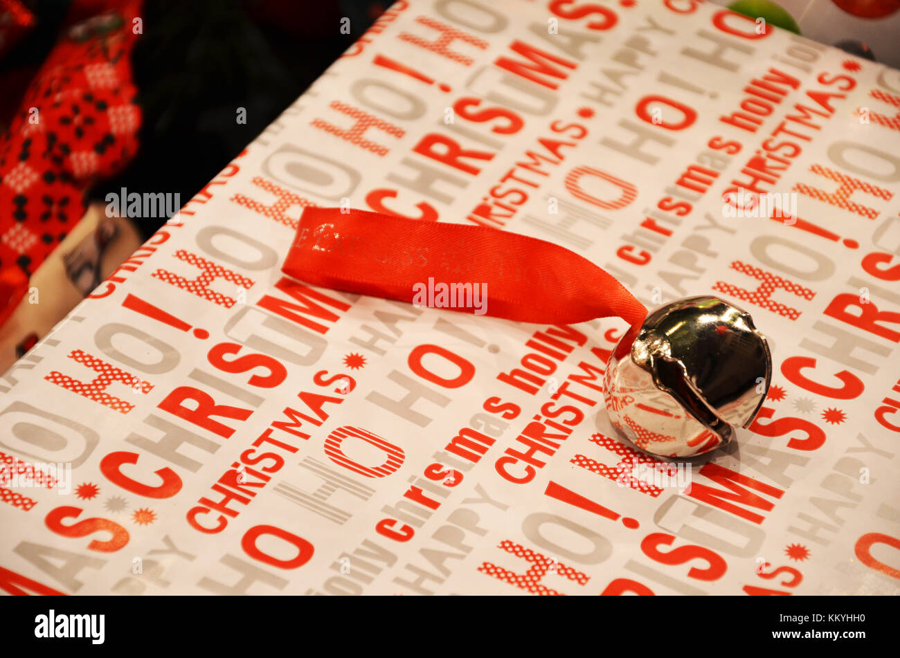 Bild einer Glocke gebunden mit einem roten Band auf ein Weihnachtsgeschenk. Stockfoto