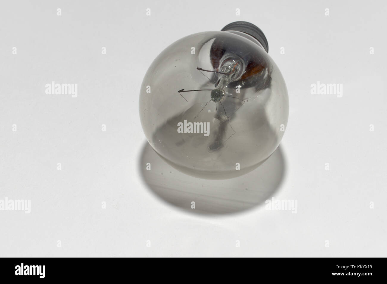 Veraltete Glühlampe mit einer Basis- und einer zerrissenen Wolframwendel Stockfoto