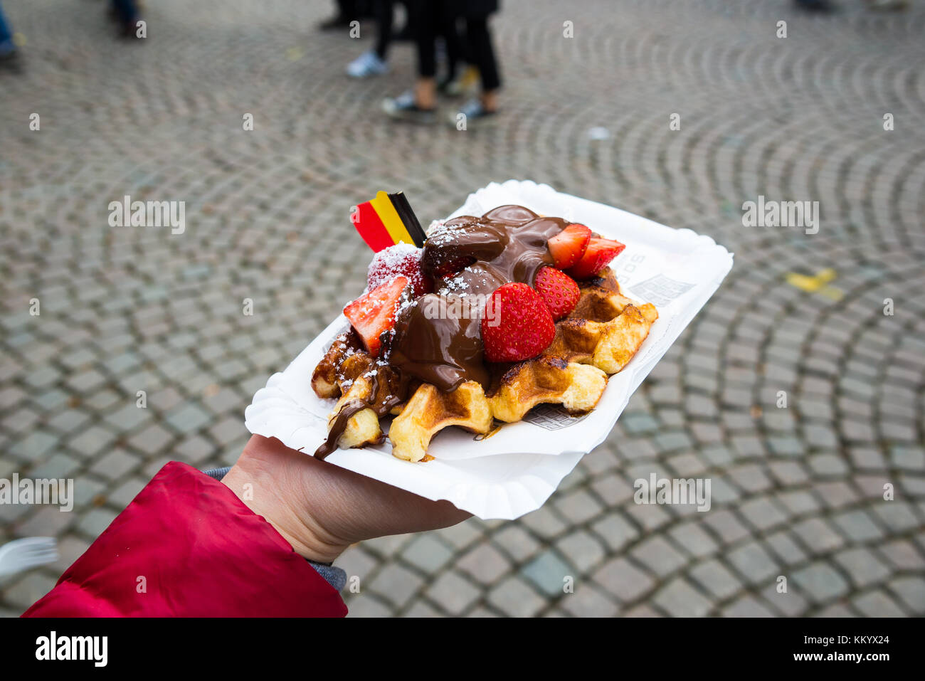 Belgien Waffel mit Schokoladensauce und Erdbeeren, im Hintergrund die Stadt Brügge, Belgien. Stockfoto