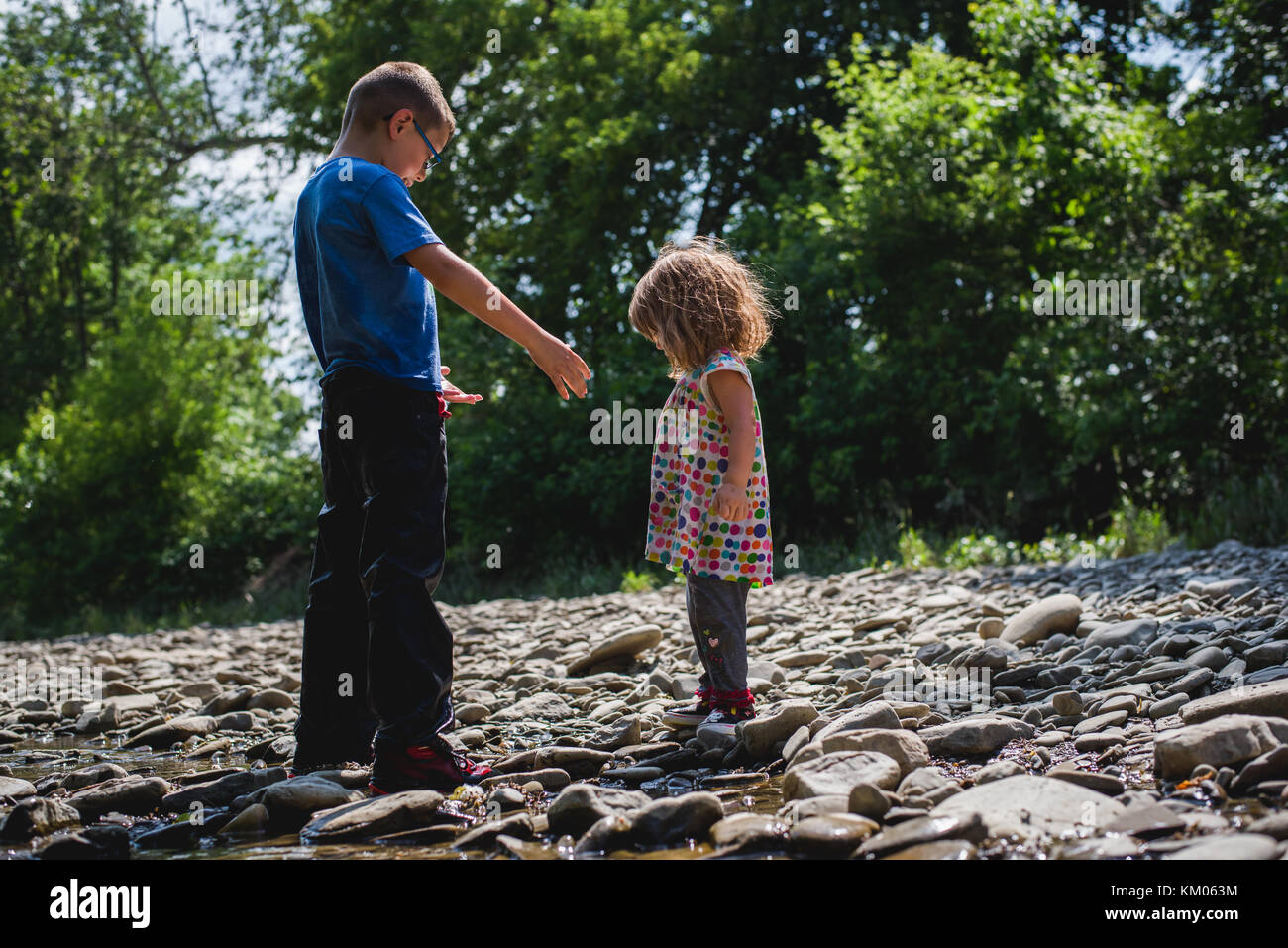 Einen kleinen Jungen und Mädchen in einen Bach an einem Sommertag. Stockfoto