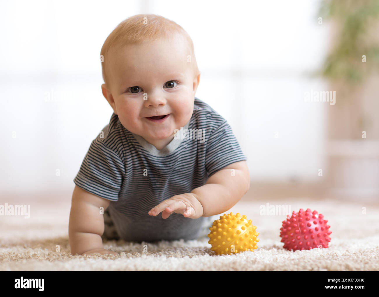 Adorable Baby krabbelte auf flauschigen Teppich zu Hause Stockfoto
