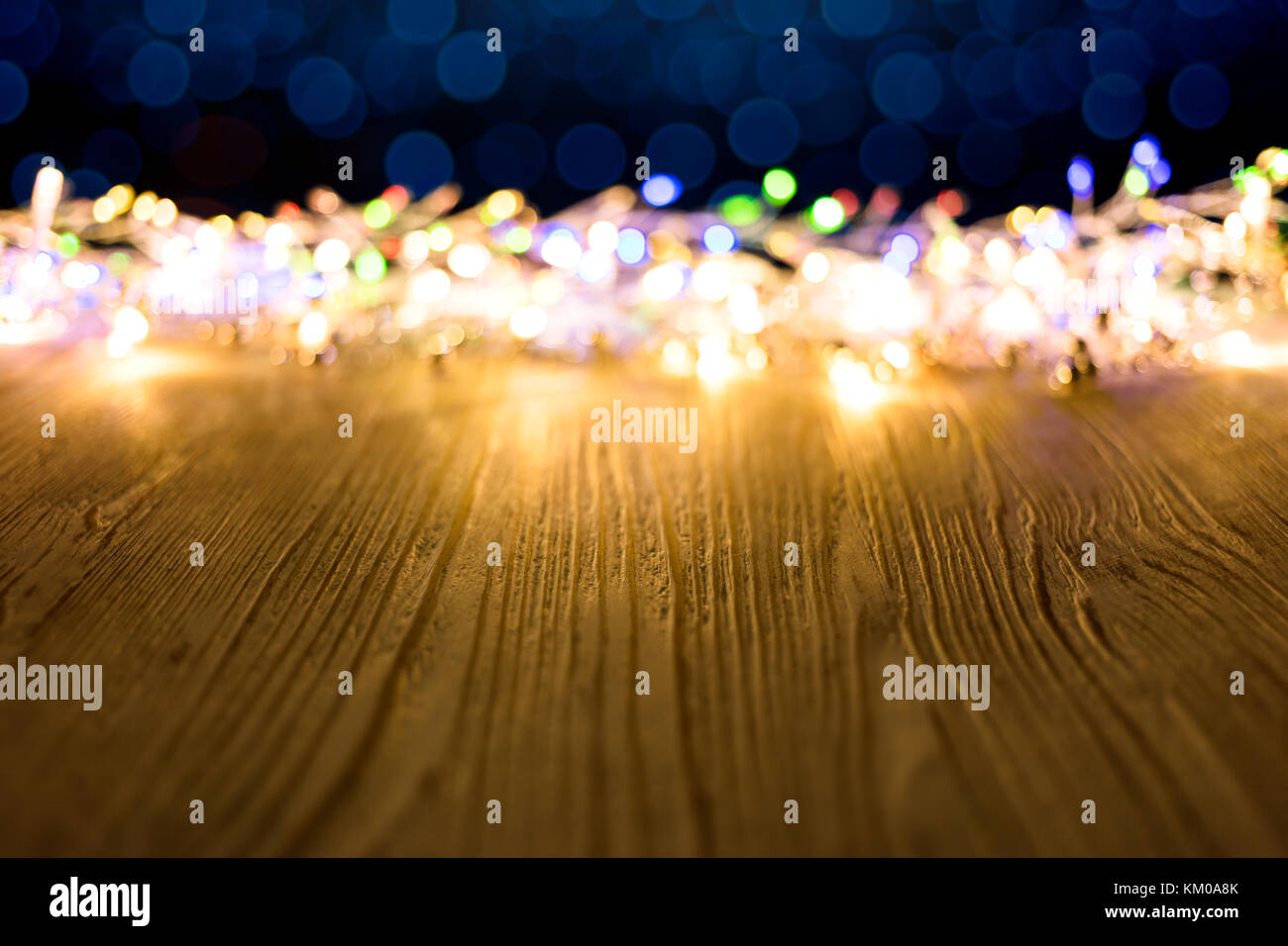 Bunte blurry festliche Weihnachtsbeleuchtung auf Holz rustikale Platten Hintergrund Stockfoto