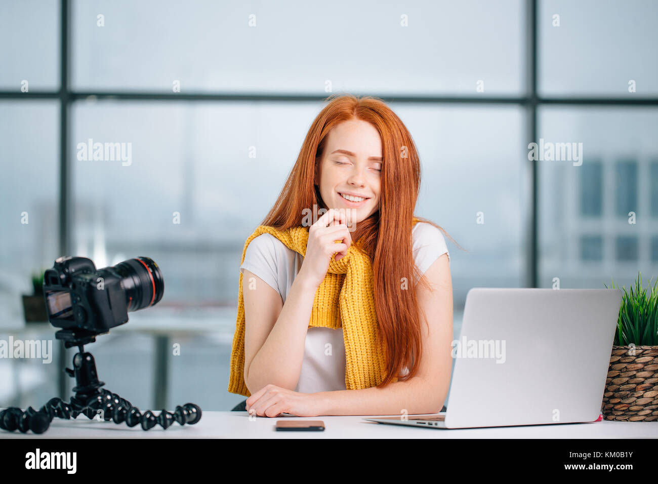 Happy rothaarige weibliche Blogger mit Laptop über neues Theme für vlog Stockfoto