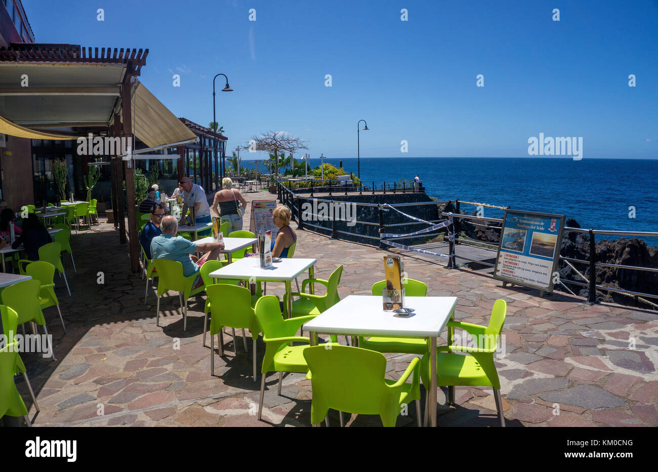 Leute an einem Strand cafe zwischen Los Gigantes und Puerto de Santiago, an der Westküste der Insel Teneriffa, Kanaren, Spanien Stockfoto